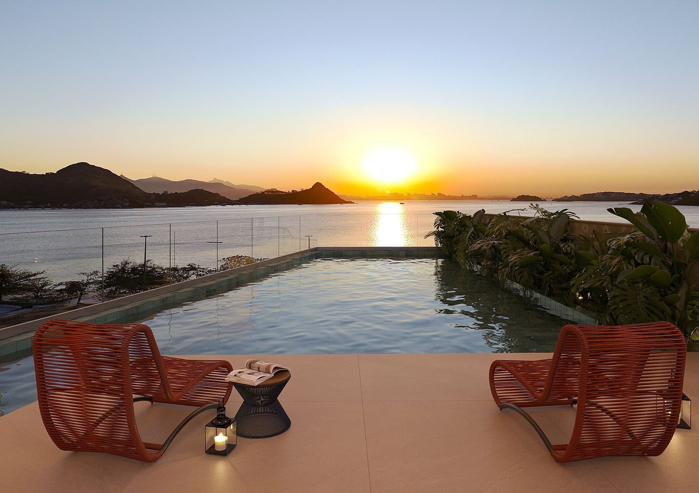 Perspectiva da piscina do rooftop do Sou+ Charitas ao pôr do sol, com vista para a enseada